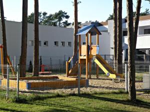 a playground with a yellow slide in a park at Apartament Sweet Home Pogorzelica in Pogorzelica