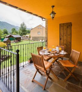 a table and chairs on a patio with a view at Apartamentos Rurales L´Abiseu in Caboalles de Abajo