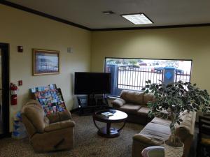 a living room with couches and a flat screen tv at Regency Inn & Suites Beaumont in Beaumont