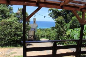 a view from the porch of a house with the ocean in the background at PANORAMA Ocean View Cottage in Motobu