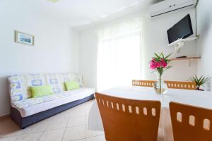 a living room with a table and a couch at Apartments Mrva in Ugljan