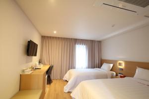 una camera d'albergo con due letti e una televisione di Angel Hotel a Busan
