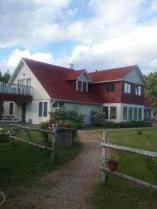 a large white house with a red roof at Atpūtas komplekss Lakši in Usma