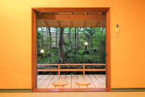 a room with a window with two benches on a deck at Hanafubuki in Ito