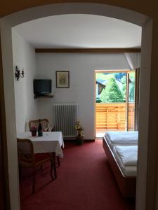 a room with a table and a bed and a window at Gasthof Sprenger in Sillian