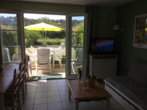 a living room with a table and an umbrella at 3 bedrooms Holiday Home Golf Resort Port-Bourgenay in Talmont