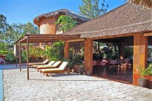 een paviljoen met ligstoelen en een patio met een tafel bij Edena Kely in Mahajanga