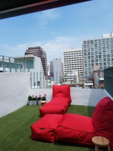 a red couch sitting on top of a roof at Hostel Single Single in Busan