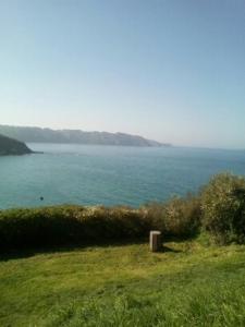 a large body of water with a trash can in the grass at Gîte Anne et Jean in Pordic