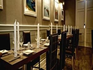 jadalnia z długim stołem i krzesłami w obiekcie Anchor Hotel and Seabed Restaurant w mieście Tarbert