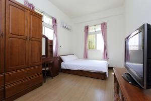 a small bedroom with a bed and a television at Kimdawn Homestay in Jinsha