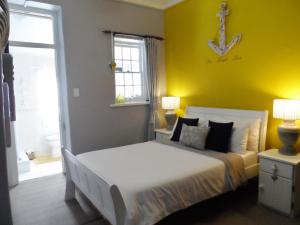a bedroom with a bed and a anchor on the wall at Sea View Charming Stone House in Mossel Bay