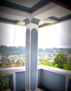 een kamer met 2 ramen met uitzicht op de stad bij Jaya Tomodachi in Kandy
