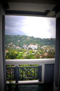 een raam met uitzicht op de stad bij Jaya Tomodachi in Kandy