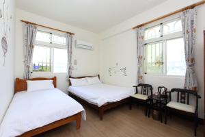 two beds in a room with two windows at Kimdawn Homestay in Jinsha