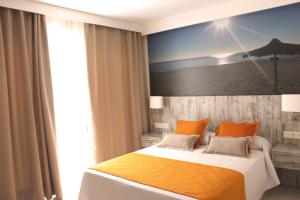 トレモリノスにあるApartamentos Casa Floridoのベッドルーム1室(大型ベッド1台、オレンジ色の枕付)