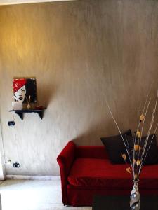 a living room with a red couch and a shelf at Casa Tua a Piazza del Popolo in Rome