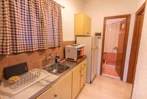 una cucina con lavello e frigorifero di Green Corner Villas a Gouviá