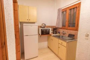 una piccola cucina con frigorifero e forno a microonde di Green Corner Villas a Gouviá