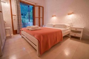 een slaapkamer met een bed met twee handdoeken erop bij Green Corner Villas in Gouvia