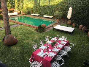 a table with a red tablecloth and chairs next to a pool at La Tierra Roja in Aliseda