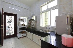a large kitchen with a refrigerator and a sink at Kimdawn Homestay in Jinsha