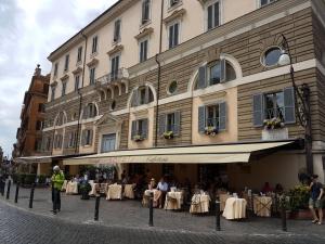 a building with a restaurant with tables in front of it at Casa Tua a Piazza del Popolo in Rome