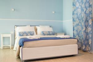 a bedroom with a bed with blue walls at B&B Gioia Resort in Marina di Ragusa
