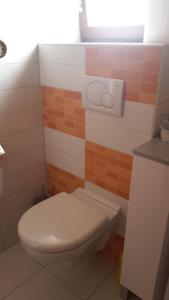 ein Badezimmer mit einem weißen WC und orangefarbenen Fliesen in der Unterkunft Ferienwohnung Claudia & Dino in Lahnstein