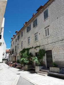 a large stone building with palm trees in front of it at Central Rooms Split in Split