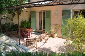 una casa y un patio con mesa y sillas en Au vallon rouge (Suite double), en Saint-Paul-de-Vence
