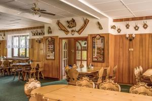 a restaurant with wooden walls and tables and chairs at Hotýlek u Kance in Lipova Lazne