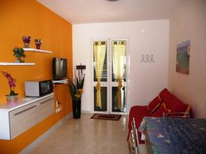 トッレ・デル・オルソにあるAppartamento12 Sol&Marのオレンジ色の壁のリビングルーム、テレビ付きの部屋