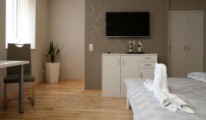 ein Schlafzimmer mit einem Bett und einem TV an der Wand in der Unterkunft Haus am See Rossbach in Roßbach