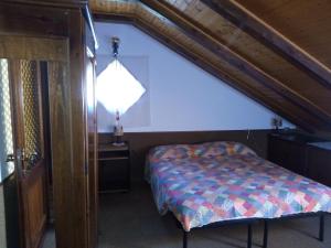 een slaapkamer met een bed, een tafel en een lamp bij Il Giardino di Marina in Santa Maria Maggiore