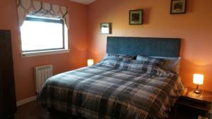 a bedroom with a bed with a blue headboard and a window at Greenacres Holiday Cabins in Leuchars