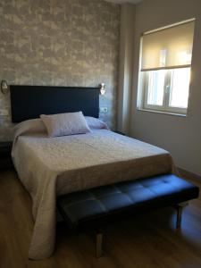 um quarto com uma cama grande e uma janela em Apartamentos Mitreo em Mérida