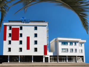a white and red building with a palm tree at Otel Vona in Ordu