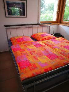 a bed with a colorful quilt on it in a bedroom at Apartment mit Gartenblick in Forchheim