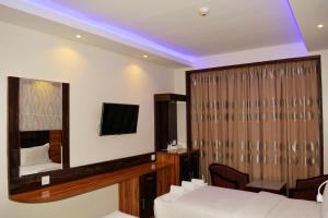 - une chambre avec un lit, un miroir et une télévision dans l'établissement Zagy Hotel, à Dubaï