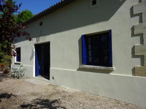 a white house with a blue door at Tour Rouge Gites in Virazeil