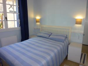 una camera con un letto blu e bianco e una finestra di Tour Rouge Gites a Virazeil