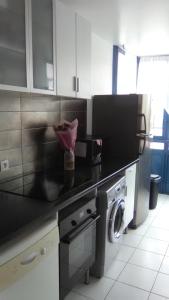 a kitchen with a black counter top and a dishwasher at Appartements Sully in Mantes-la-Jolie +2 photos