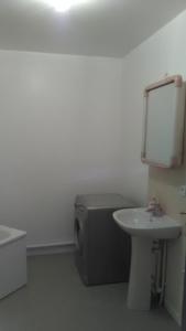 a white bathroom with a sink and a toilet at Appartements Sully in Mantes-la-Jolie