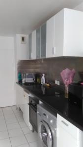 a kitchen with a black counter top and a dishwasher at Appartements Sully in Mantes-la-Jolie