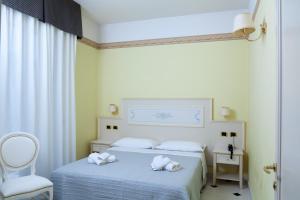 a bedroom with a bed with towels on it at Residence Record in Rimini +38 photos