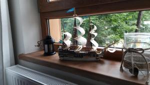 um pequeno modelo de navio sentado no parapeito de uma janela em Apartament Anna Park Rodzinna em Mielno
