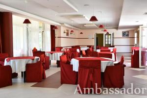 un restaurant avec des tables et des chaises rouges et blanches dans l'établissement Hotel Ambassador - Free Parking, aux Sables d'or