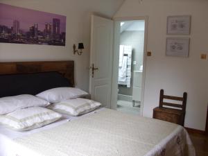 una camera con un letto bianco con due cuscini di Marcia Donatti - A l'Ombre des Coteaux Sao Paulo a Kaysersberg