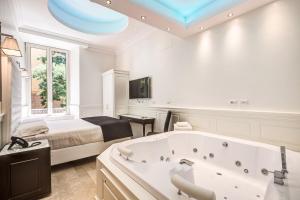een slaapkamer met een groot bad en een bed bij Hotel dei Quiriti Suite in Rome